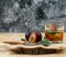 Close-up plums and knife on wooden board with detox water,a piece of sack and leaves on wooden board and dark blue marble background. horizontal